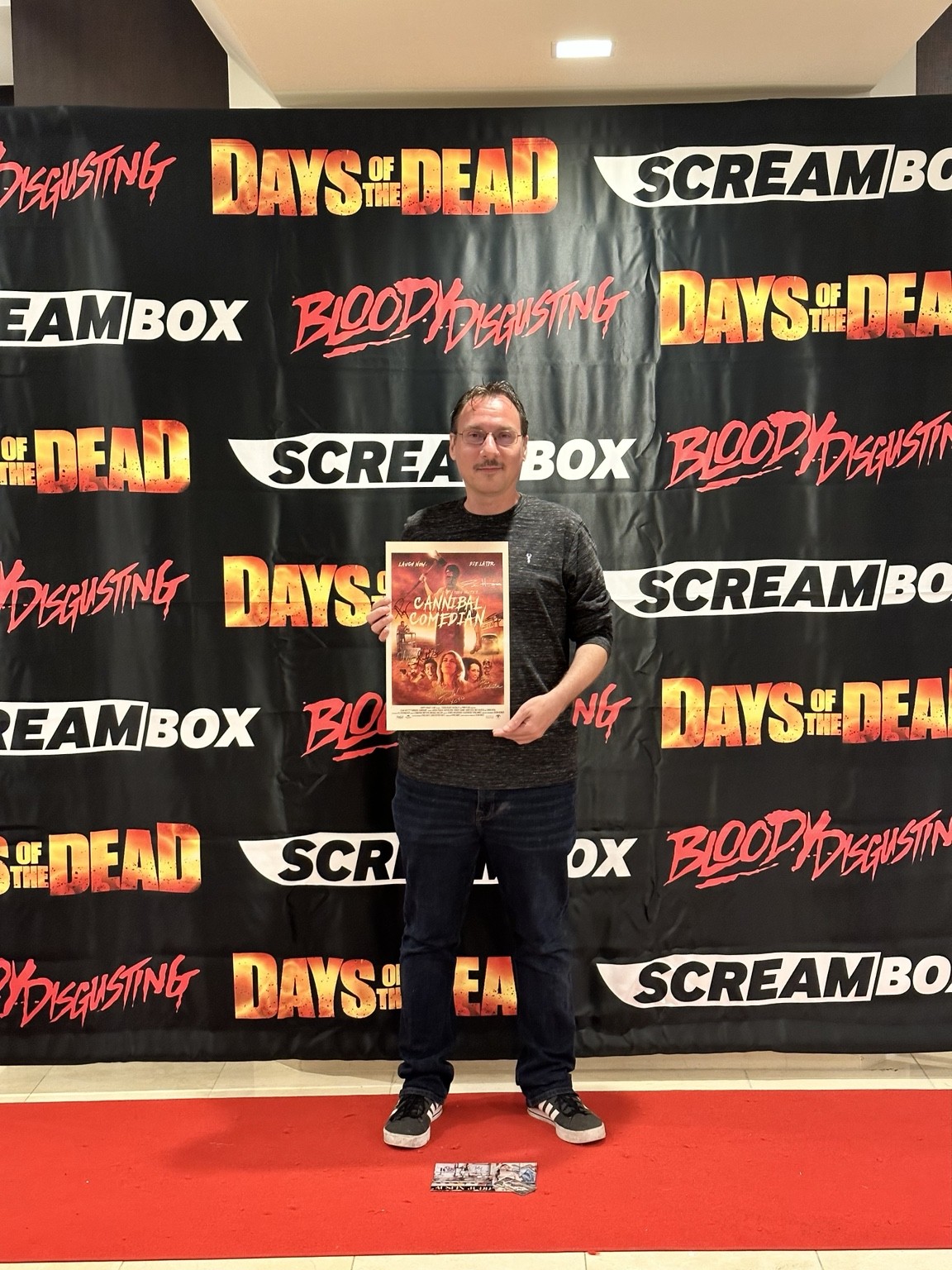 C.J. Guerrero holding a framed item at Days of the Dead
